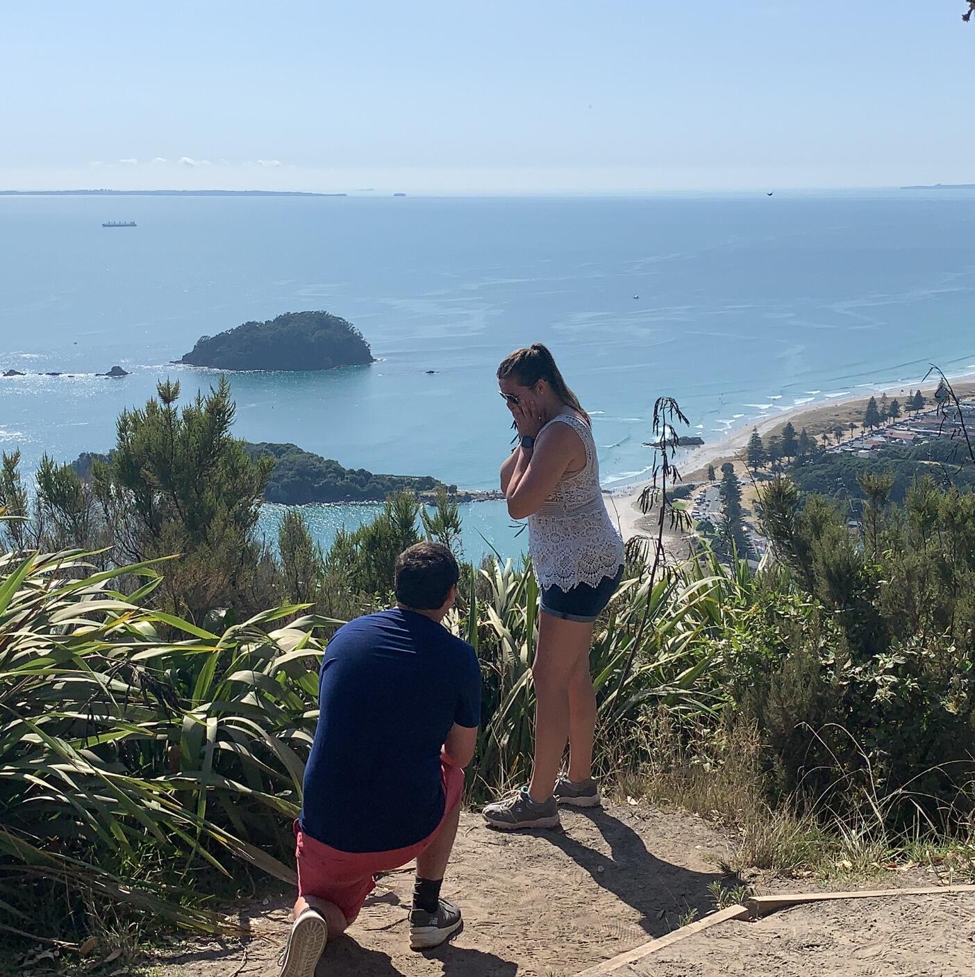 Andrew proposed on the top of Mt. Maunganui in Tauranga, New Zealand. We were on a 3 week trip to Australia and New Zealand and Andrew waited until the second to last stop on the cruise to propose. The hike up the mountain took a few hours and it was almost 100 degrees. I kept offering to turn around but Andrew was very insistent. He showed me a spot where you could stand on the edge and see the ship when he got down on one knee. It also happened to be Australia Day so the ship that night was one big party, a great way to celebrate with all our friends! 