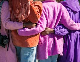 four women walking in colorful coats