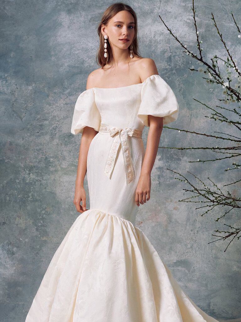 markarian white silk off the shoulder mermaid wedding dress with floral embroidery tied waist puffy sleeves and pleated flowy skirt
