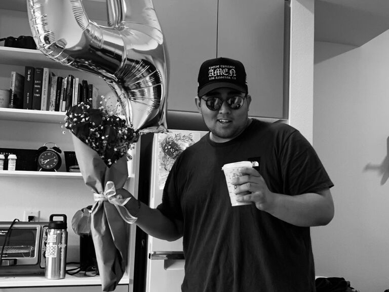 On our 4-month dating anniversary, I caught Dylan in the act of prepping a surprise—coffee, flowers, and a balloon. Clearly, he was trying to secure the "best boyfriend ever" title early on!