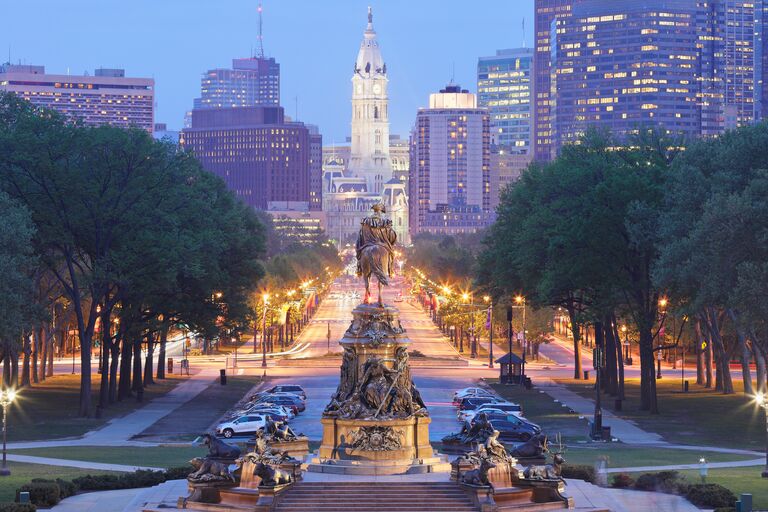 philadelphia at night with ben franklin facing down the city hall building from a distance
