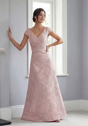 Bold, modern, and effortlessly chic, this Gemma Jacquard A-line gown is a show-stopping choice for the Mother of the Bride. The V-neckline and short sleeves beautifully frame the shoulders, while a gathered bodice at the natural waistline sculpts and flatters the figure. Practical yet stylish pockets add a contemporary twist, and the flowing A-line skirt creates graceful movement with every step. Perfectly blending elegance, comfort, and on-trend design, this gown makes a confident, unforgettable statement.