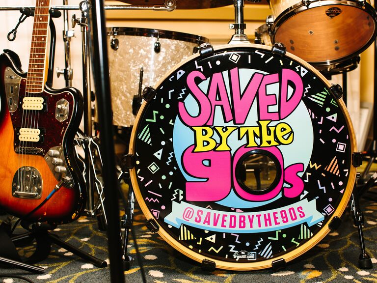 A drum set that says "Saved By The 90s" on it. 