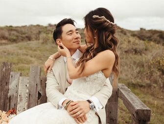Bride with twisted half-up hairstyle sitting in groom's lap