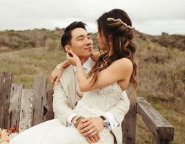 Bride with twisted half-up hairstyle sitting in groom's lap