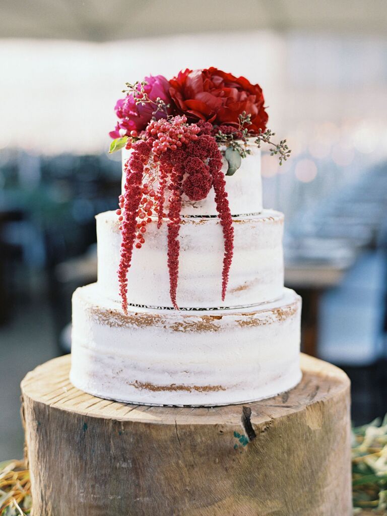 Rustic semi-naked three-tier wedding cake with crimson flowers
