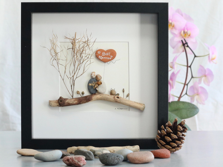 Embracing couple with small branch, twig and pebbles in frame
