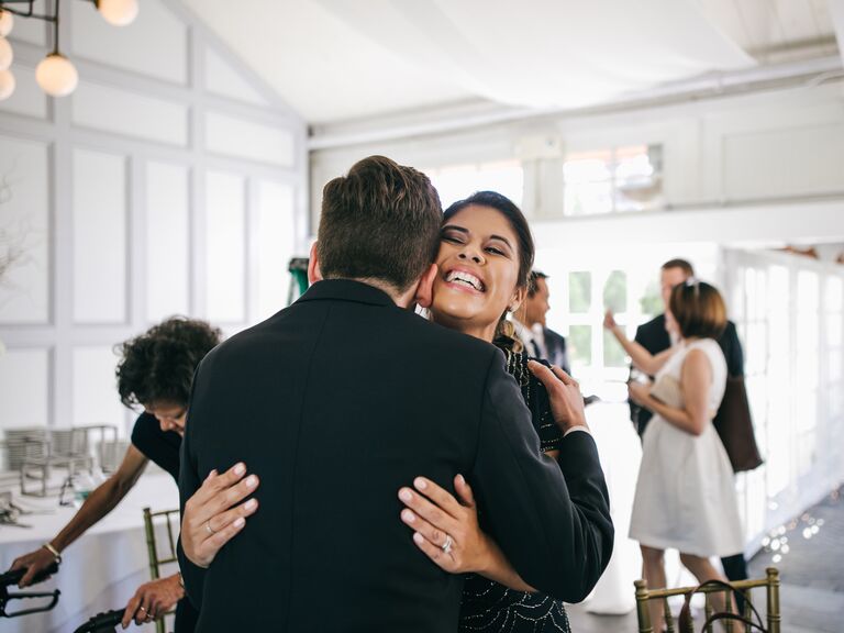 Brother and sister hugging at wedding reception.