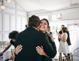 Brother and sister hugging at wedding reception.