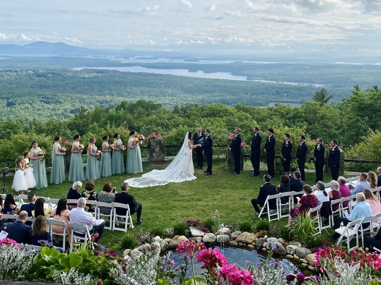 Couple exchanging vows in a garden surrounded by loved ones and beautiful scenery
