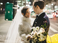 Bride wearing faux fur coverup at winter wedding with groom