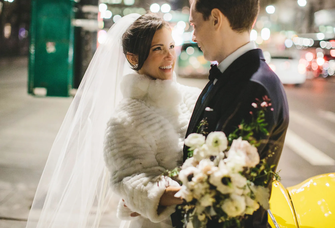 Bride wearing faux fur coverup at winter wedding with groom