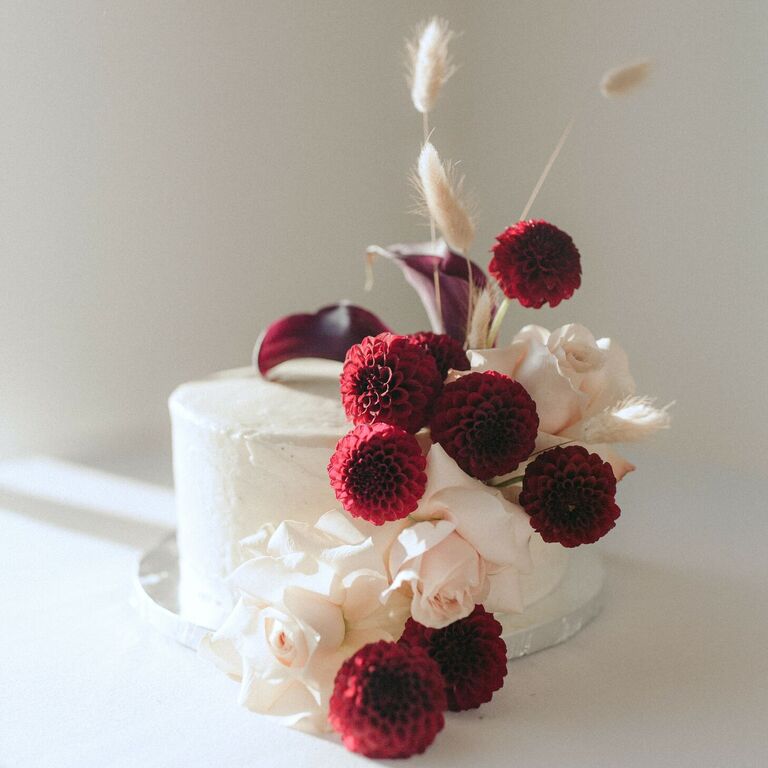 One-tier cake with fresh burgundy dahlia and cally lily blooms.