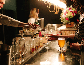 Bartender pouring guest a drink at cash bar.