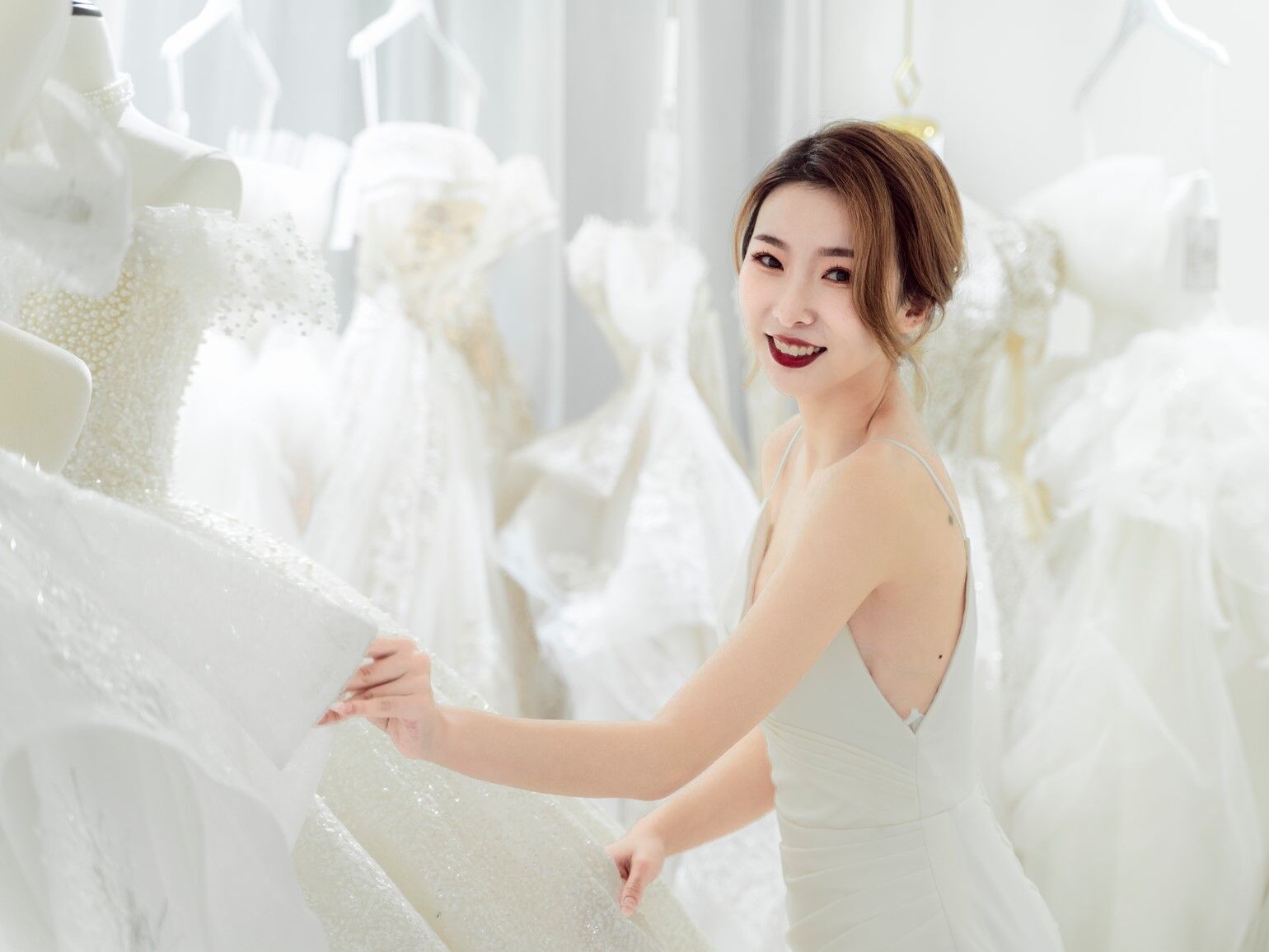 Bride smiling while looking at wedding dresses