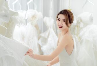 Bride smiling while looking at wedding dresses