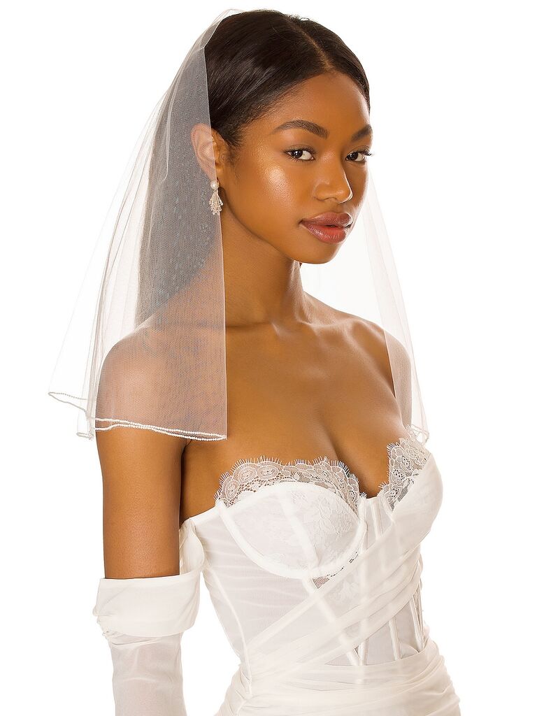 Model wears a shoulder-length sheer veil. 