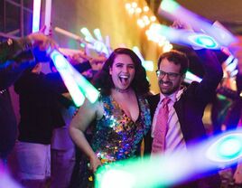 Bride and groom dancing at reception with colored light sticks