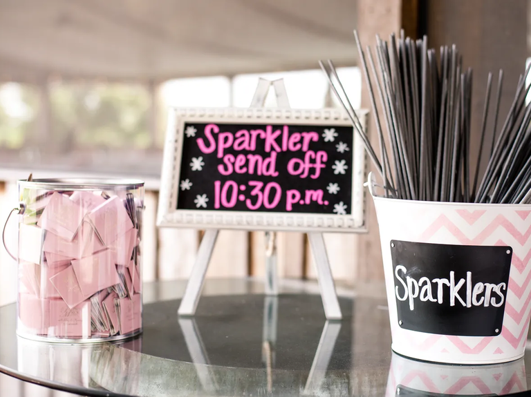 Pink-themed wedding sparkler send-off station with matching custom matchbooks