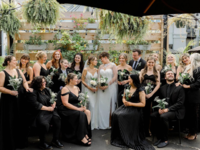 Brides surrounded by their wedding party and guests dressed in black