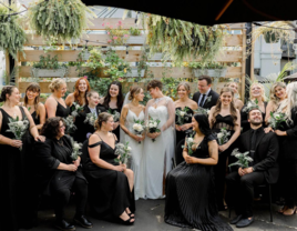 Brides surrounded by their wedding party and guests dressed in black