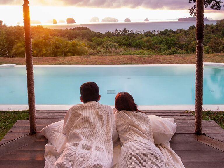 Couple laying together looking at sunset over ocean in Bali