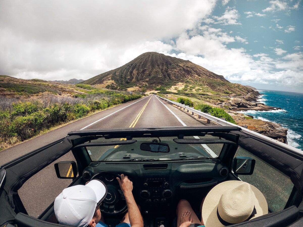 People in a jeep driving on the road.