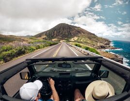 People in a jeep driving on the road.