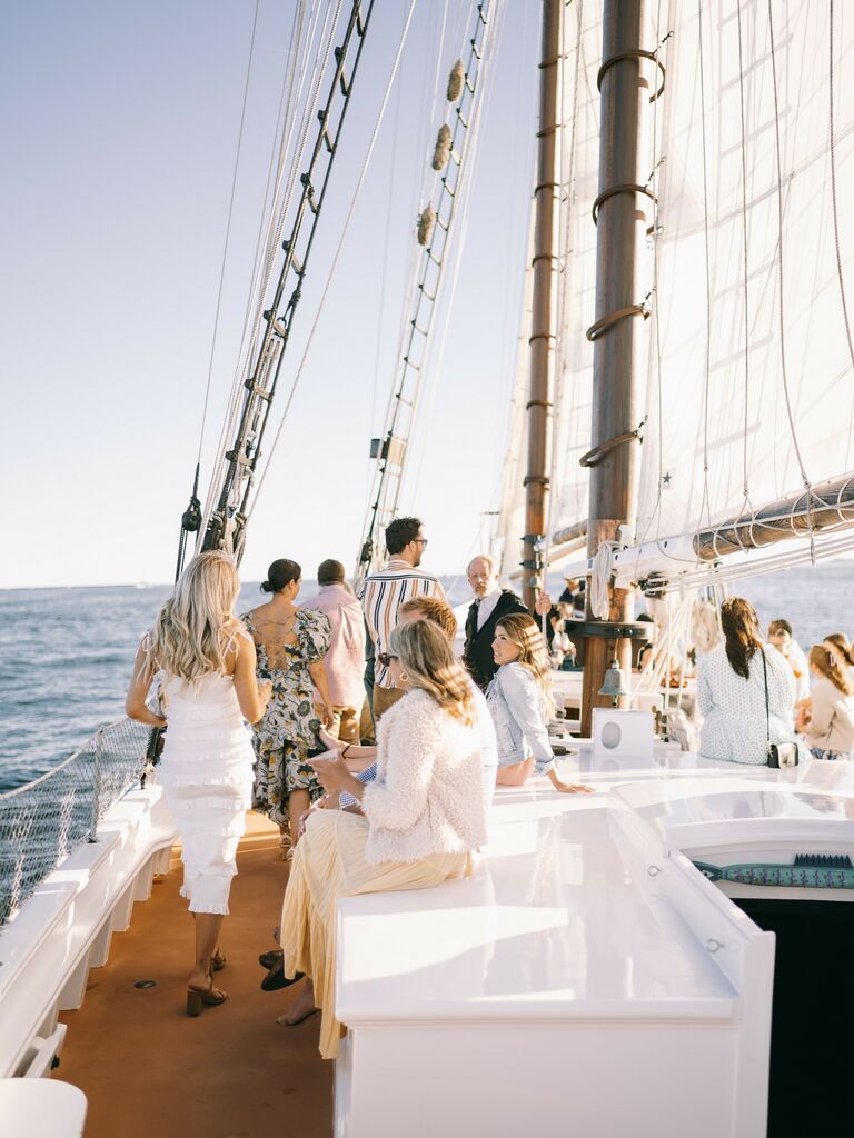 couple with their wedding guests on a sailboat