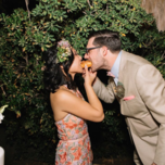 Bride and groom sharing late night wedding snack donut