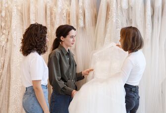 Bride looking at wedding dresses with friends