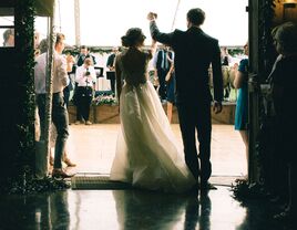 Bride and groom walking into reception