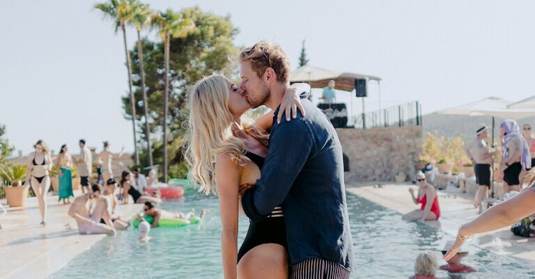 couple kissing during pool joint bachelor-bachelorette party fun