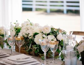 white floral and greenery centerpiece in low wooden rectangular trough