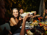 Wedding guests passing plates and enjoying family-style dinner at reception