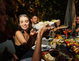 Wedding guests passing plates and enjoying family-style dinner at reception