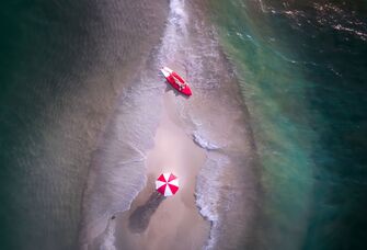 couple on kayak and beach umbrella on sand bar for a honeymoon ideas