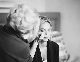 Bride getting her makeup done on her wedding day