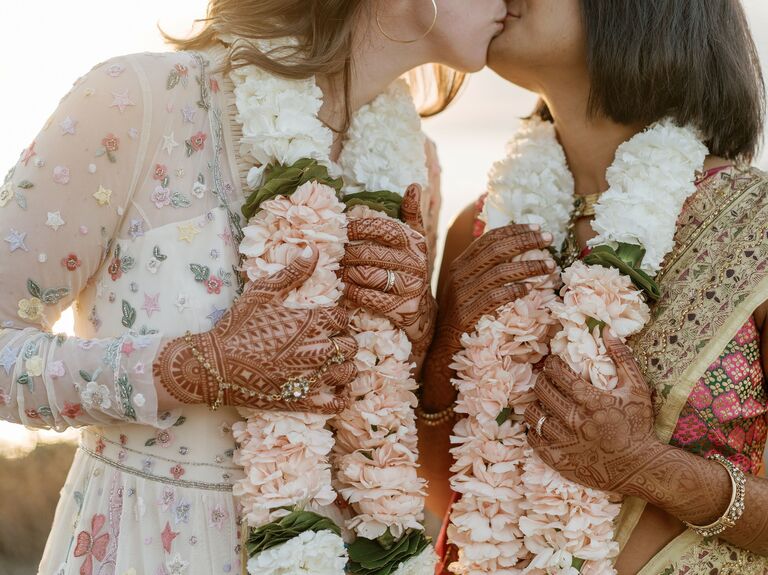 Couple kiss while wearing beautiful leis. 