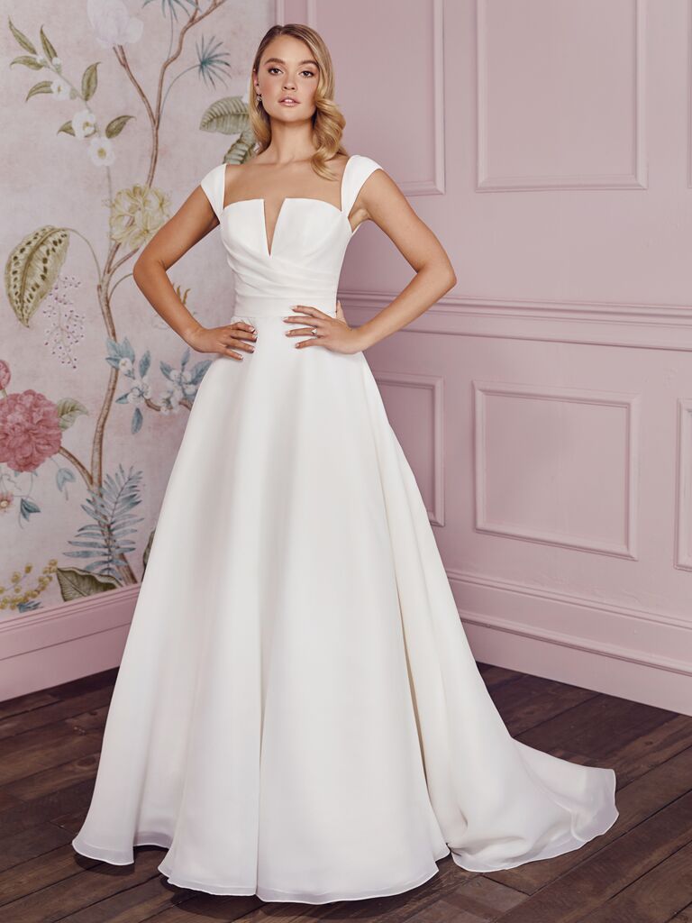 model wearing a-line wedding dress with notched neckline and cap sleeves