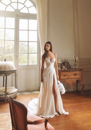 Kassel gown is a strikingly modern bridal statement, designed for brides who embrace lightness, movement, and contemporary elegance. Crafted from chiffon organza, the fabric gives the dress an airy, dynamic feel with a subtle, refined sheen. The corset is richly draped, creating depth and texture, while the shell-shaped cups add a unique sculptural accent to the bodice. A deep leg slit brings a bold, fashion-forward touch, perfectly balanced by the soft fluidity of the skirt. The gown fastens with a zipper at the back and is finished with a small, delicate train that completes the look with effortless grace. Fresh, lightweight, and ultra-modern - Kassel gown is perfect for confident brides who want a sophisticated yet daring bridal look.