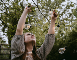 Woman hanging up string lights for wedding