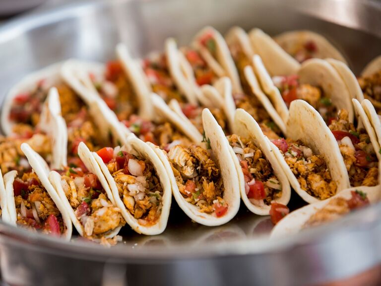 Platter of mini soft-shell tacos with a meat filling and pico de gallo topping. 