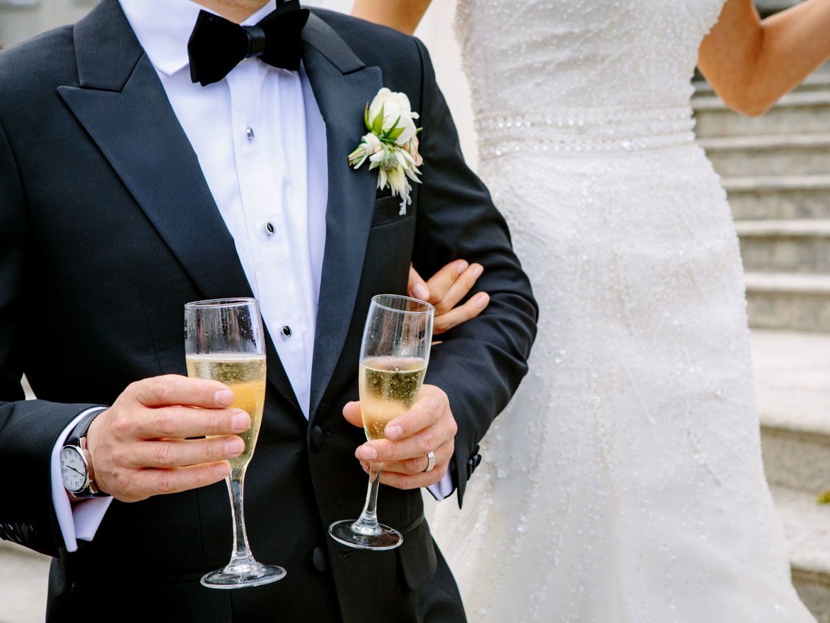 Bride with groom holding champagne