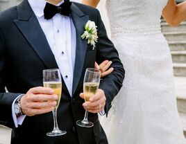 Bride with groom holding champagne