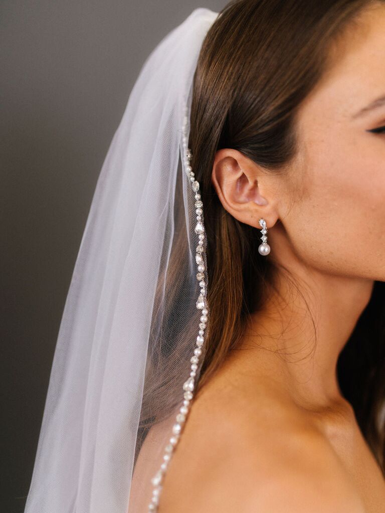 Model wears dainty veil with a natural pearl border. 