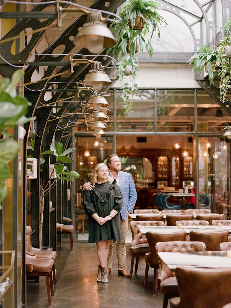 Couple pose for their summer engagement photo session indoors. 