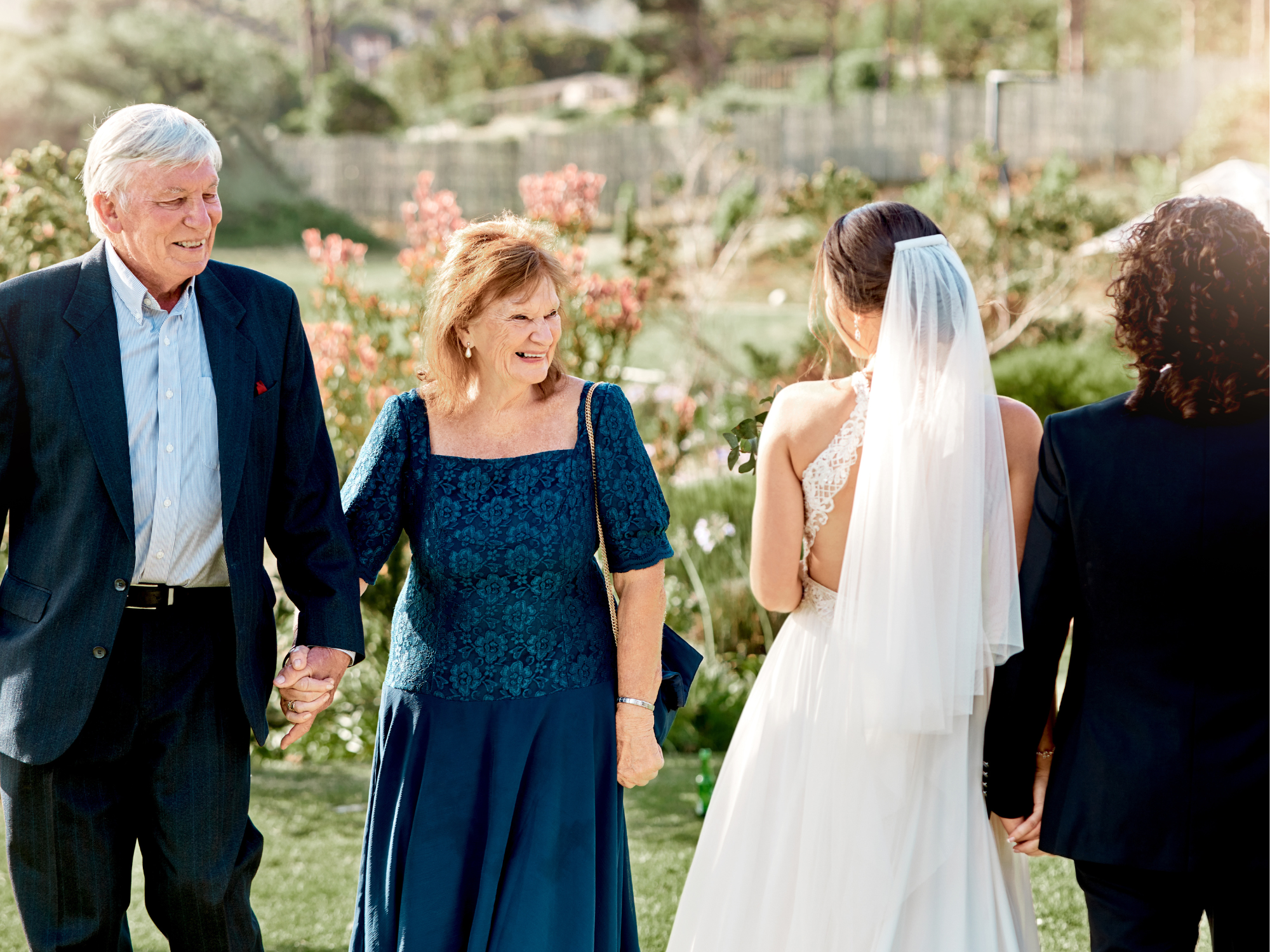 Parents smiling with child and partner on wedding day