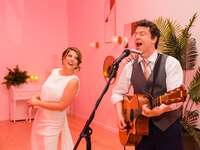 couple performing with guitar at reception in Los Angeles, CA