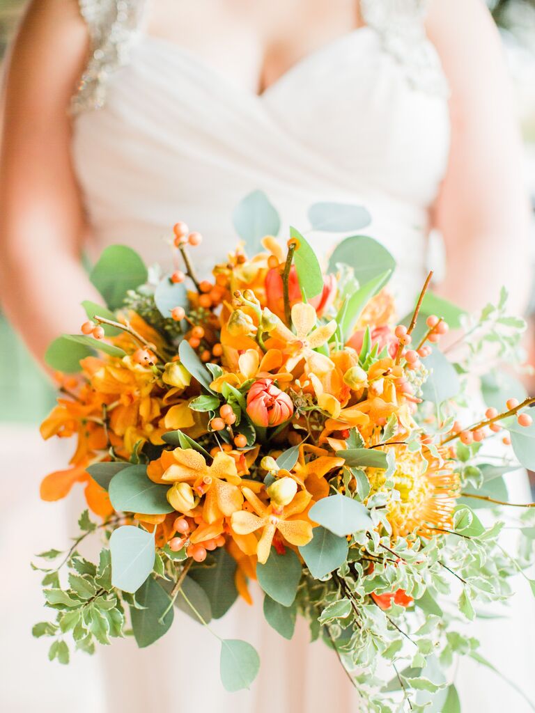 Bride holding a bright orange bouquet.